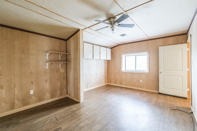 7528 Gainesville St, Houston, TX 77020 - unfurnished bedroom with vaulted ceiling, wood finished floors, wood walls, and a ceiling fan