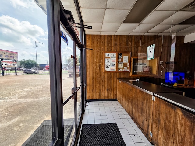 7528 Gainesville St, Houston, TX 77020 - kitchen with wooden walls, a drop ceiling, light tile patterned floors, and brown cabinetry