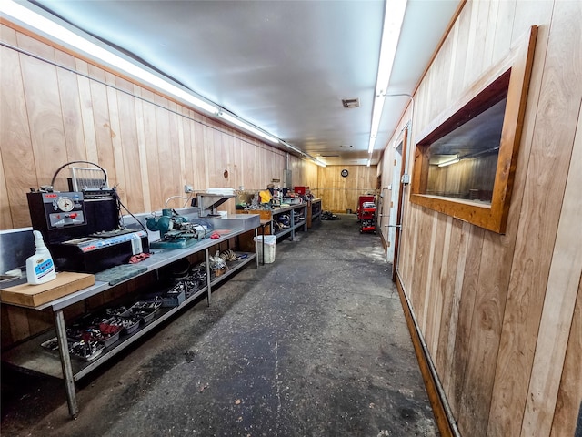 7528 Gainesville St, Houston, TX 77020 - miscellaneous room featuring a workshop area, wooden walls, and concrete flooring
