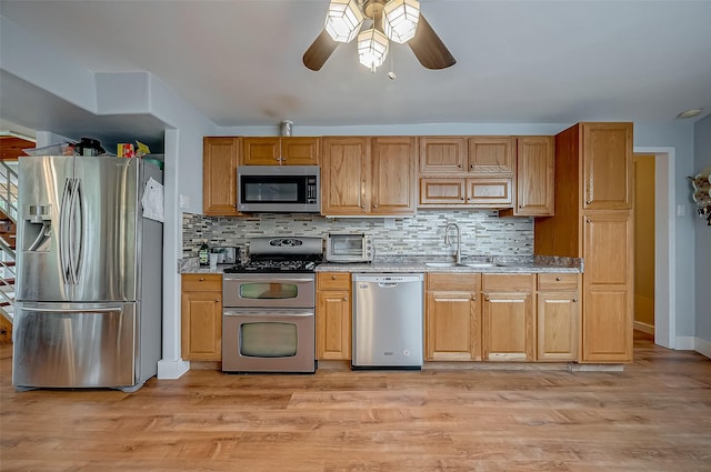 22914 Whittaker Way, Spring, TX 77373 - kitchen with stainless steel appliances, a ceiling fan, decorative backsplash, and light wood finished floors