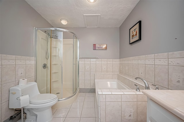 22914 Whittaker Way, Spring, TX 77373 - bathroom featuring tile walls, a textured ceiling, a stall shower, a bath, and tile patterned flooring