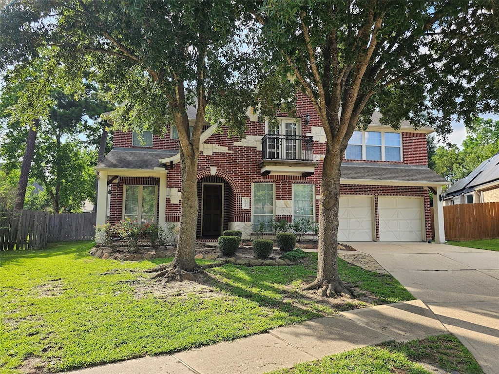 403 Woodpecker Forest Ln, Conroe, TX 77384 - view of front of home featuring a balcony, driveway, a garage, and brick siding