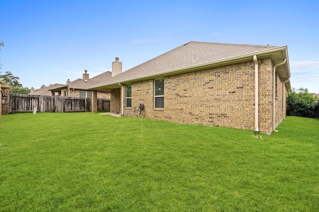 5107 Preserve Park Dr, Spring, TX 77389 - back of property featuring a fenced backyard, a chimney, brick siding, and a shingled roof