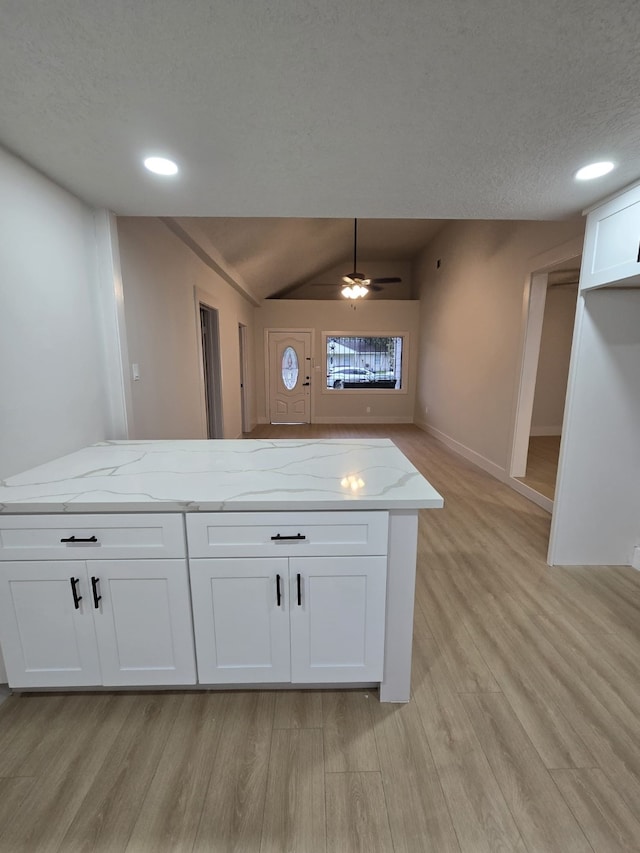 5326 Dewberry St, Houston, TX 77021 - kitchen featuring light wood-style flooring, light stone counters, vaulted ceiling, a textured ceiling, and recessed lighting