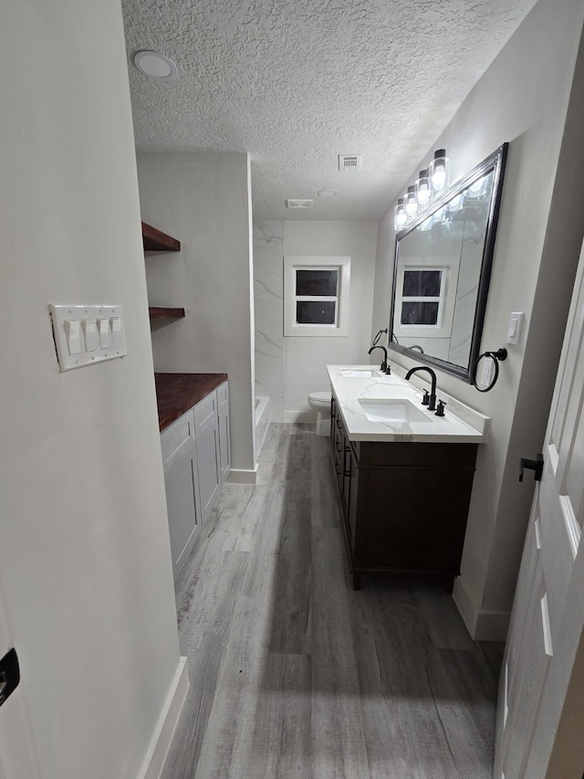 5326 Dewberry St, Houston, TX 77021 - bathroom featuring double vanity, wood finished floors, a shower, and a textured ceiling