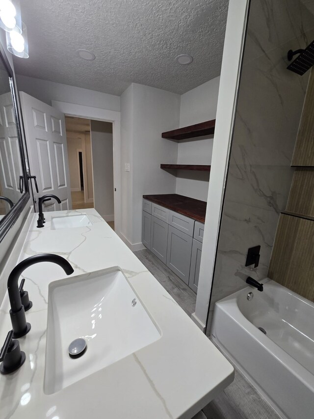 5326 Dewberry St, Houston, TX 77021 - full bathroom featuring double vanity, shower / bath combination, a textured ceiling, and wood finished floors