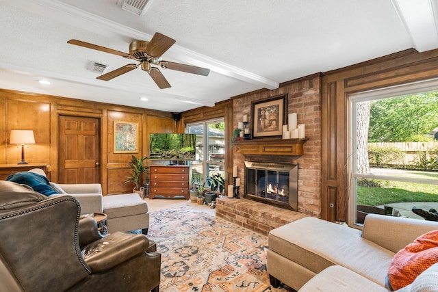 9611 Stockport Dr, Spring, TX 77379 - living area with wood walls, healthy amount of natural light, a ceiling fan, beamed ceiling, and a fireplace