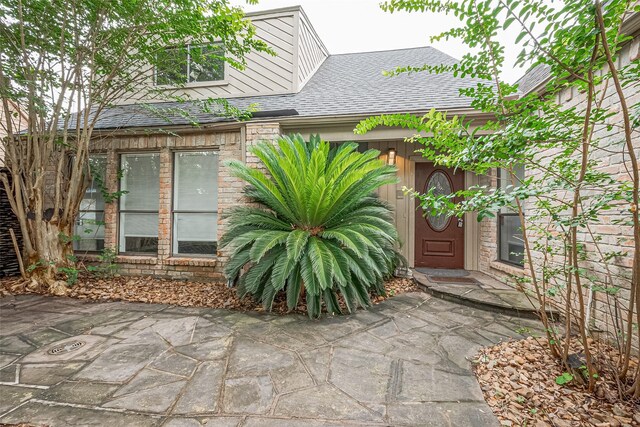 2107 Shadowbriar Dr, Houston, TX 77077 - doorway to property featuring a shingled roof and a patio