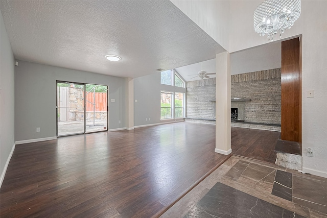 2107 Shadowbriar Dr, Houston, TX 77077 - unfurnished living room featuring wood finished floors, a brick fireplace, a chandelier, a textured ceiling, and ceiling fan