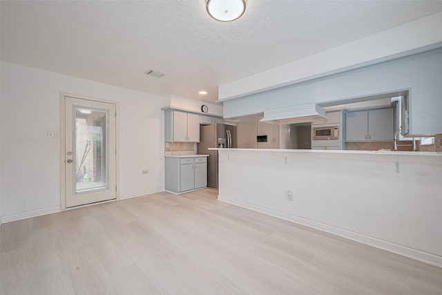 2107 Shadowbriar Dr, Houston, TX 77077 - unfurnished living room featuring light wood-type flooring and a textured ceiling