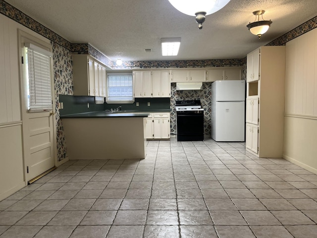 7541 Werner St, Houston, TX 77037 - kitchen with freestanding refrigerator, gas stove, a textured ceiling, under cabinet range hood, and a peninsula
