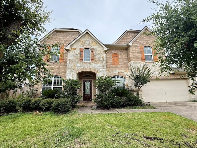 12503 Pepper Creek Ln, Pearland, TX 77584 - french country home with concrete driveway, a front lawn, stone siding, and brick siding