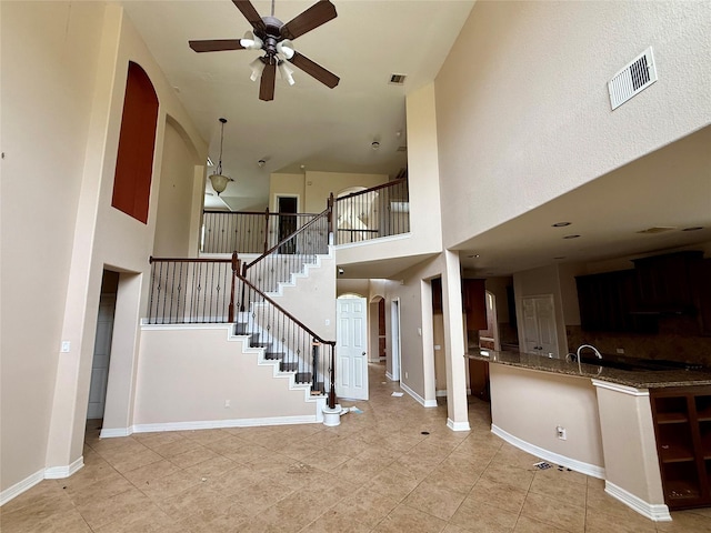 12503 Pepper Creek Ln, Pearland, TX 77584 - staircase featuring arched walkways, a ceiling fan, a towering ceiling, and tile patterned flooring