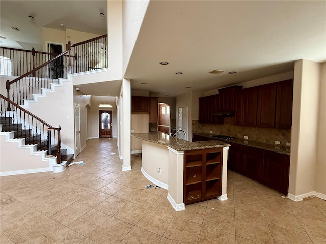 12503 Pepper Creek Ln, Pearland, TX 77584 - kitchen featuring arched walkways, light tile patterned floors, tasteful backsplash, open shelves, and a high ceiling