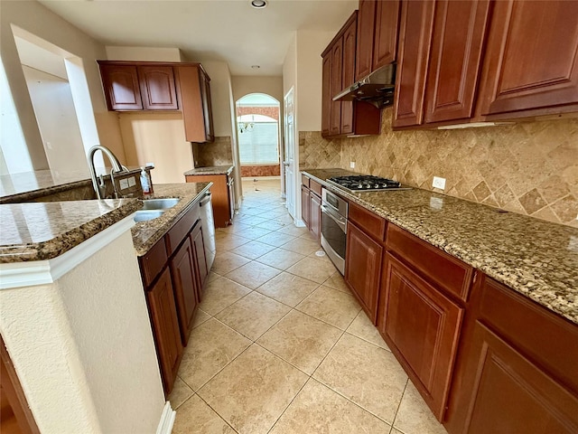 12503 Pepper Creek Ln, Pearland, TX 77584 - kitchen with under cabinet range hood, appliances with stainless steel finishes, dark stone countertops, backsplash, and recessed lighting