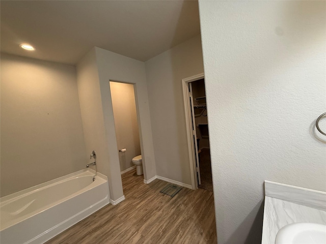 6106 Yesenia St, Katy, TX 77449 - full bath featuring wood finished floors, a garden tub, a walk in closet, and recessed lighting