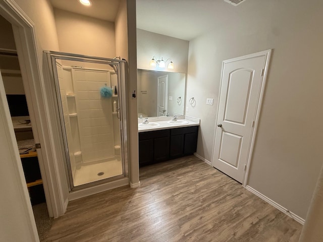 6106 Yesenia St, Katy, TX 77449 - bathroom featuring a shower stall, double vanity, wood finished floors, and a walk in closet