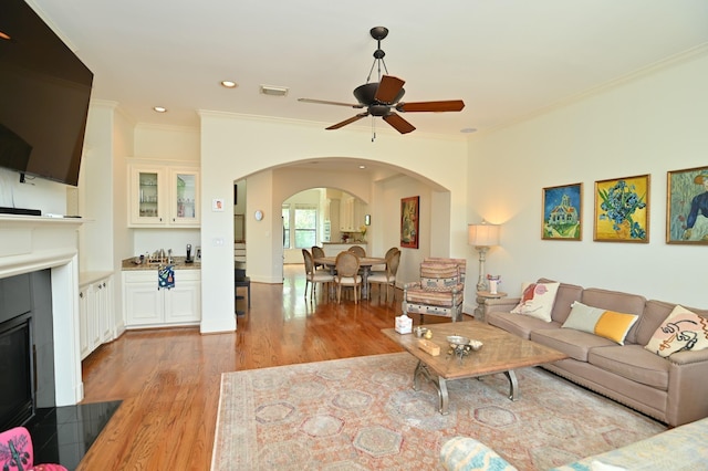 1307 W Bell St, Houston, TX 77019 - living area with arched walkways, crown molding, light wood-style flooring, a ceiling fan, and recessed lighting