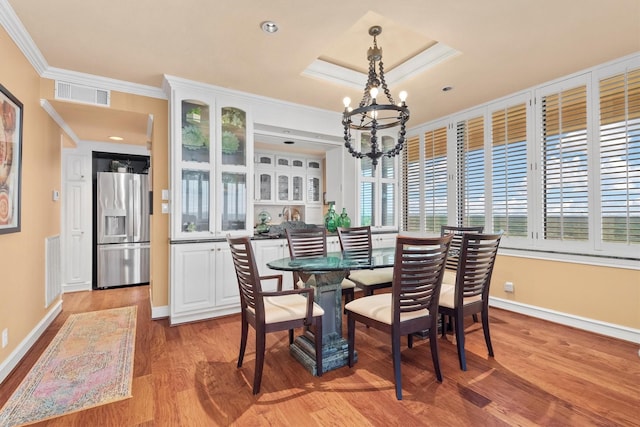14655 Champion Forest Dr Unit 1704, Houston, TX 77069 - dining space with a chandelier, light wood-style floors, crown molding, and a raised ceiling