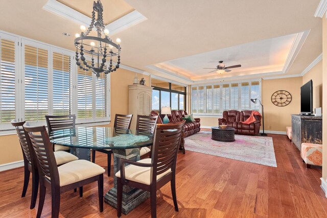 14655 Champion Forest Dr Unit 1704, Houston, TX 77069 - dining room featuring a raised ceiling, ornamental molding, a chandelier, wood finished floors, and ceiling fan