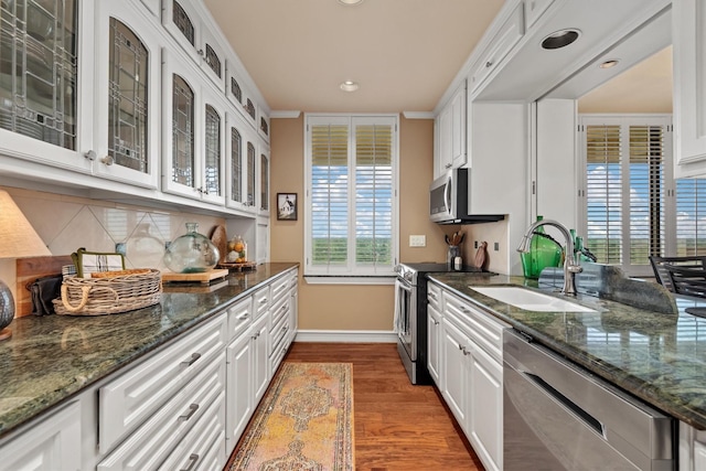 14655 Champion Forest Dr Unit 1704, Houston, TX 77069 - kitchen with appliances with stainless steel finishes, wood finished floors, white cabinetry, tasteful backsplash, and recessed lighting