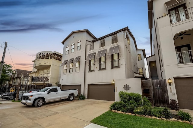 1516 Cohn St, Houston, TX 77007 - view of front facade with a garage, driveway, stucco siding, and a balcony