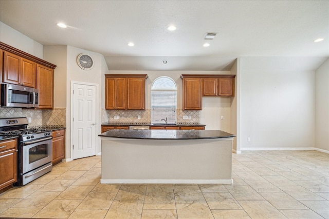 20779 Oakhurst Meadows Dr, Porter, TX 77365 - kitchen with stainless steel appliances, dark countertops, a center island, decorative backsplash, and brown cabinetry