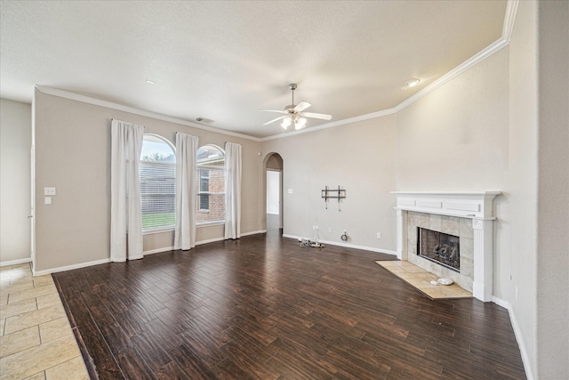 20779 Oakhurst Meadows Dr, Porter, TX 77365 - unfurnished living room with arched walkways, ceiling fan, crown molding, a fireplace, and wood finished floors