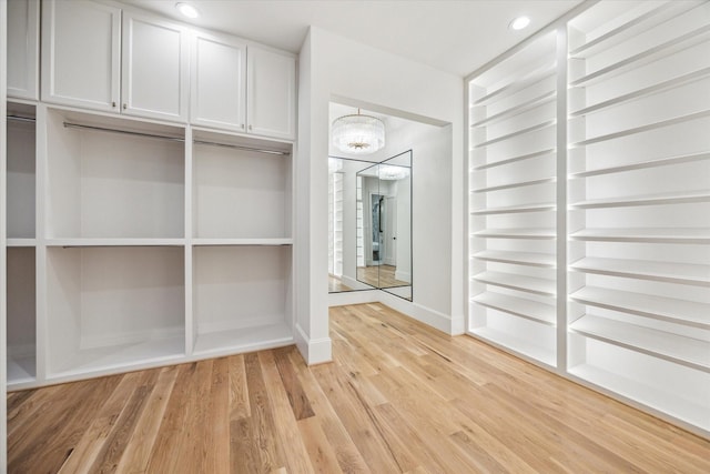 2220 Pelham Dr, Houston, TX 77019 - spacious closet featuring light wood-style flooring and a chandelier