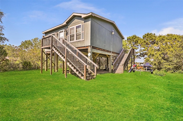 637 Troy St, Anahuac, TX 77514 - back of property with stairway, a wooden deck, and a lawn
