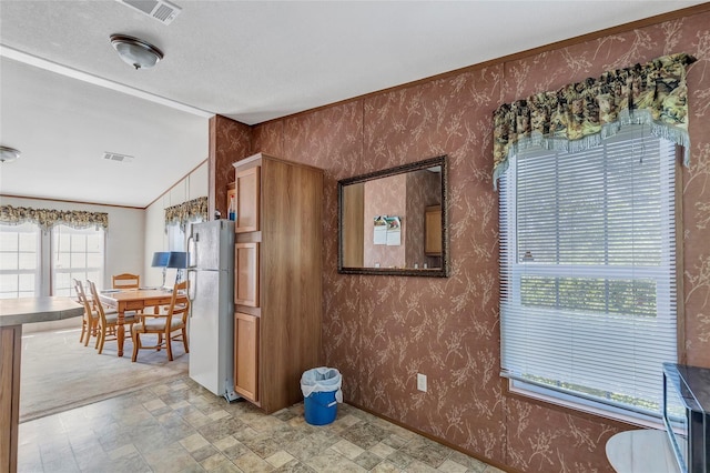 637 Troy St, Anahuac, TX 77514 - dining space with vaulted ceiling, stone finish floors, and wallpapered walls