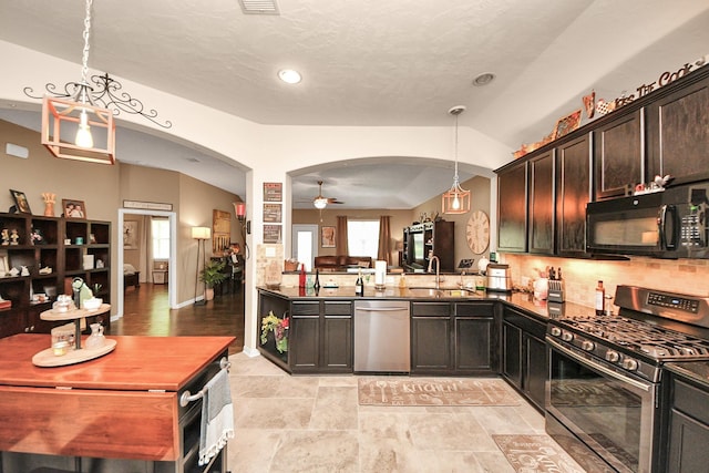 22819 Jetty Manor Ln, Spring, TX 77373 - kitchen featuring stainless steel appliances, arched walkways, ceiling fan, open floor plan, and dark countertops