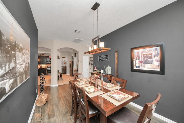 22819 Jetty Manor Ln, Spring, TX 77373 - dining area featuring arched walkways and wood finished floors