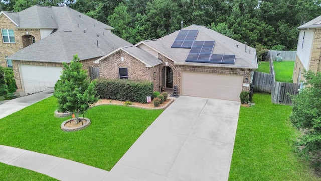 22819 Jetty Manor Ln, Spring, TX 77373 - view of front of home featuring brick siding, an attached garage, roof with shingles, and roof mounted solar panels