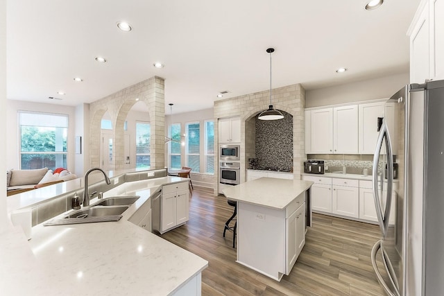 31013 Sunfall Trail Ln, Spring, TX 77386 - kitchen with appliances with stainless steel finishes, a spacious island, decorative backsplash, recessed lighting, and plenty of natural light