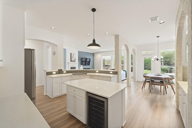 31013 Sunfall Trail Ln, Spring, TX 77386 - kitchen with beverage cooler, a center island, light wood-type flooring, recessed lighting, and freestanding refrigerator