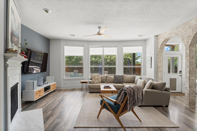 31013 Sunfall Trail Ln, Spring, TX 77386 - living area featuring a fireplace with flush hearth, a ceiling fan, wood finished floors, and a textured ceiling