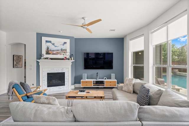 31013 Sunfall Trail Ln, Spring, TX 77386 - living room featuring wood finished floors, a premium fireplace, ceiling fan, and arched walkways