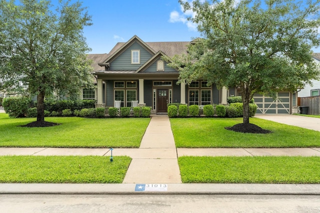 31013 Sunfall Trail Ln, Spring, TX 77386 - craftsman-style house with a front lawn, a standing seam roof, a porch, concrete driveway, and a metal roof