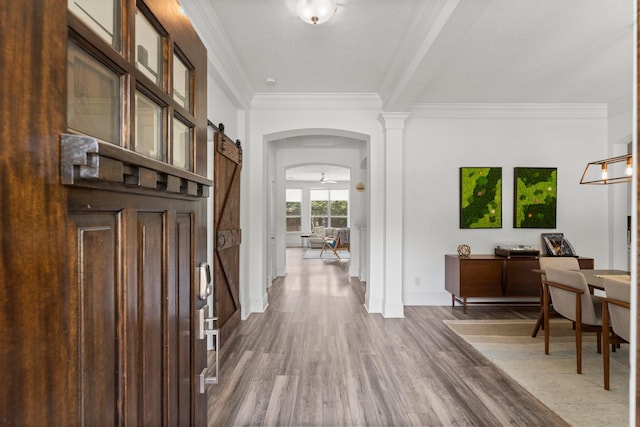 31013 Sunfall Trail Ln, Spring, TX 77386 - entryway with a barn door, crown molding, wood finished floors, and arched walkways