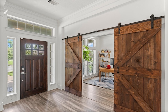 31013 Sunfall Trail Ln, Spring, TX 77386 - entrance foyer featuring a barn door, crown molding, and wood finished floors