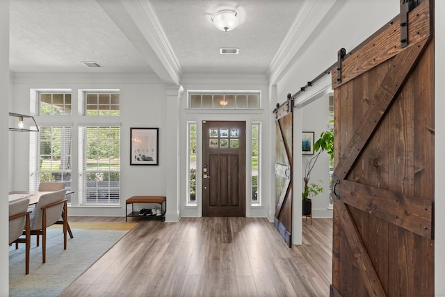 31013 Sunfall Trail Ln, Spring, TX 77386 - foyer entrance featuring a barn door, ornamental molding, and light wood finished floors