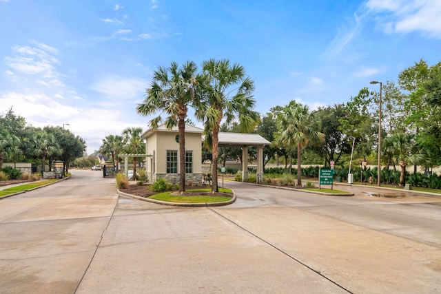 17533 Rosette Grass Dr, Conroe, TX 77385 - view of front of house with stone siding, curved driveway, stucco siding, and an attached carport