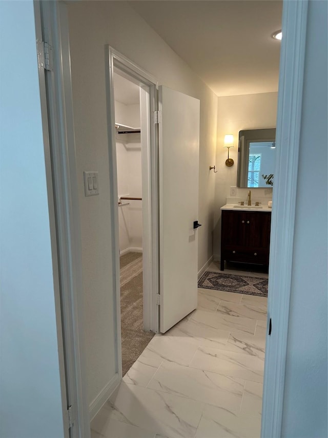 8018 Twining Oaks Ln, Spring, TX 77379 - bathroom featuring vanity, marble look tiles, and a walk in closet