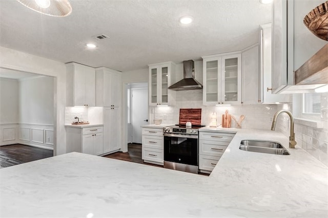 8018 Twining Oaks Ln, Spring, TX 77379 - kitchen with wall chimney range hood, stainless steel electric range oven, white cabinetry, decorative backsplash, and glass insert cabinets