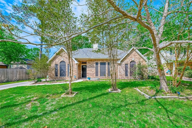 25011 Bovington Dr, Spring, TX 77389 - view of front of house with brick siding, a chimney, and roof with shingles