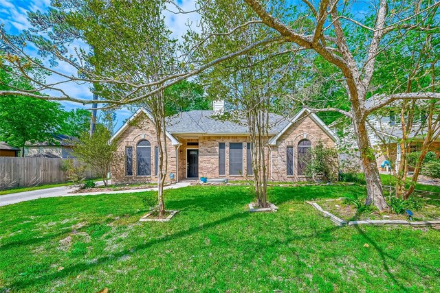 25011 Bovington Dr, Spring, TX 77389 - view of front facade with brick siding, a chimney, and roof with shingles