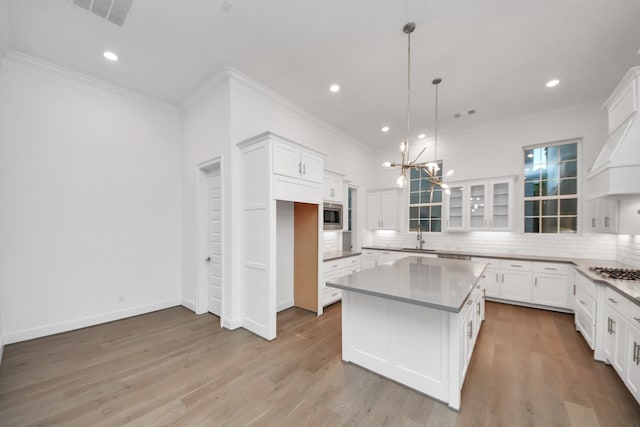 861 Dunleigh Meadows Ln, Houston, TX 77055 - kitchen with ornamental molding, decorative backsplash, stainless steel appliances, a center island, and white cabinetry