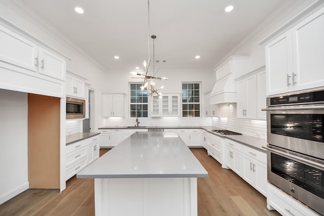 861 Dunleigh Meadows Ln, Houston, TX 77055 - kitchen with stainless steel appliances, ornamental molding, decorative backsplash, white cabinets, and a chandelier
