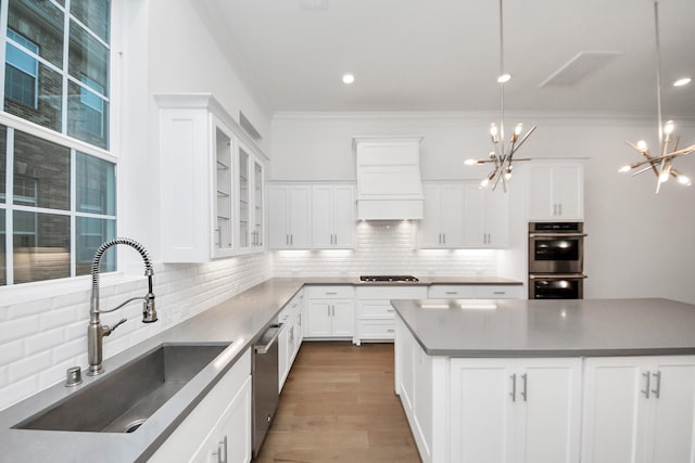 861 Dunleigh Meadows Ln, Houston, TX 77055 - kitchen with a chandelier, stainless steel appliances, custom exhaust hood, ornamental molding, and decorative backsplash